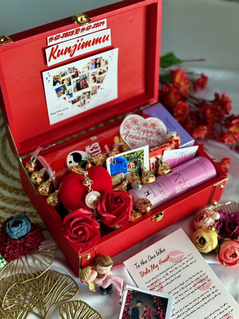 red hamper trunk box with many luxury items placed inside like perfume, flowers, watch, photos, frames and chocolates